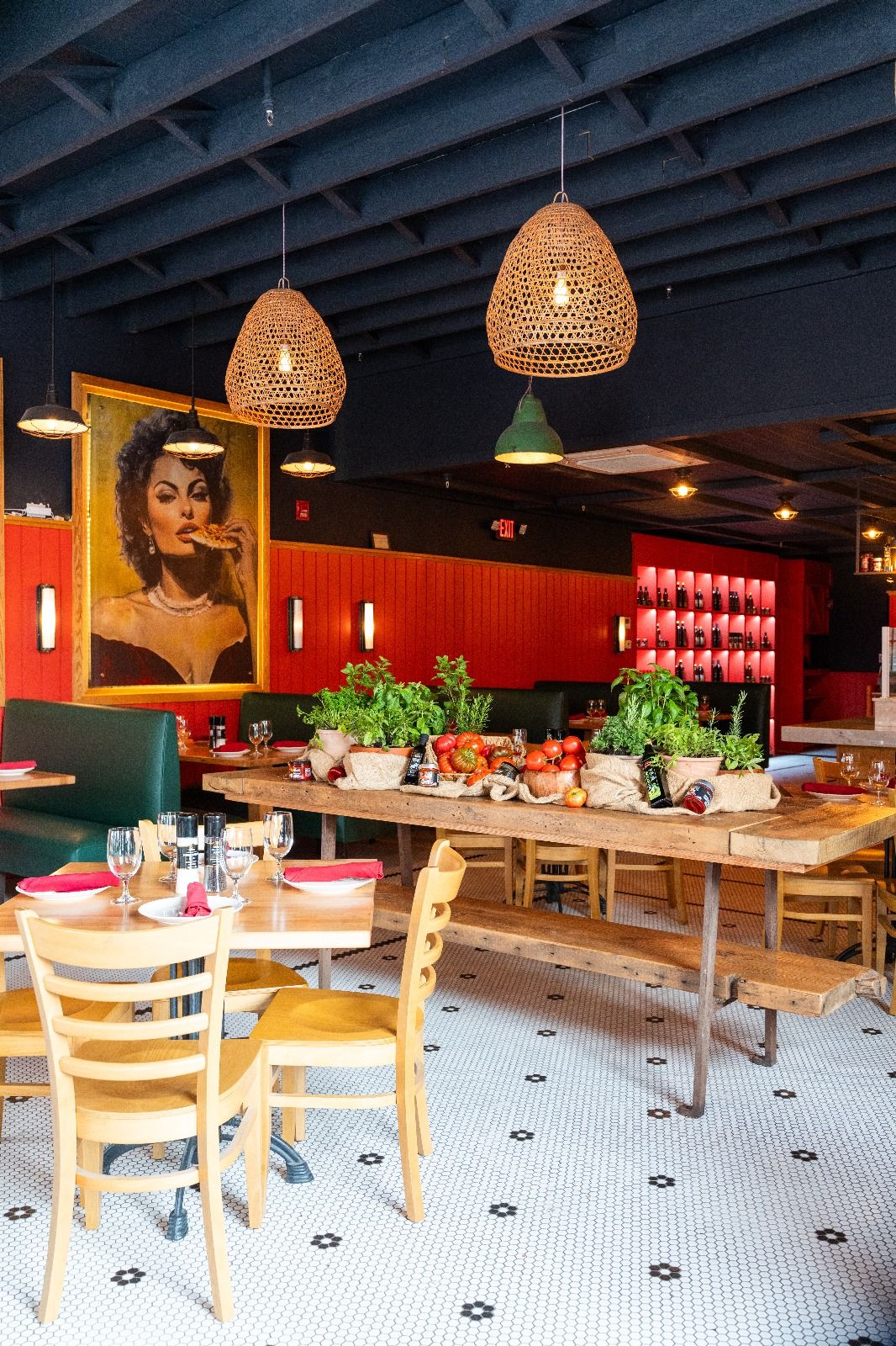 Rosolini dining room with long communal tables, woven pendant lamps and red walls